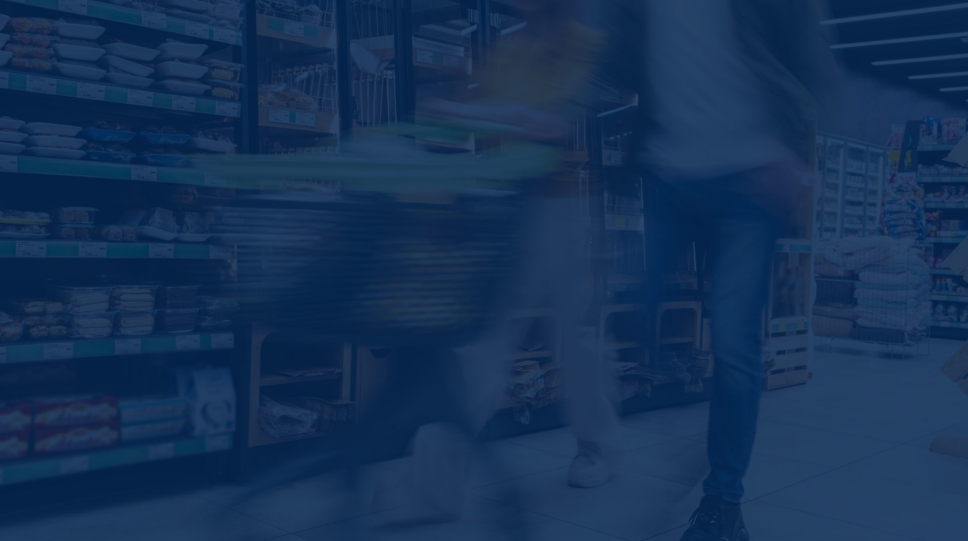 Blurred motion of a shopper pushing a cart in a grocery aisle with shelves stocked with various products, highlighting the dynamics of retail execution in FMCG.