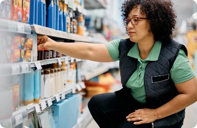 A field marketing professional arranging products on a shelf in a supermarket, showcasing data led field teams and Perfect Store execution for FMCG brands.